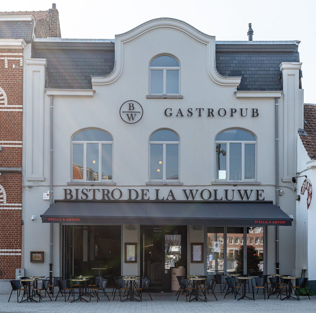 Façade du bistro de la Woluwe, notant "Gastropub" et logo B/W, avec tables extérieures